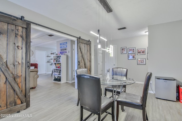 4816 55th St, Lubbock, TX 79414 - dining area with a barn door, light wood finished floors, and baseboards