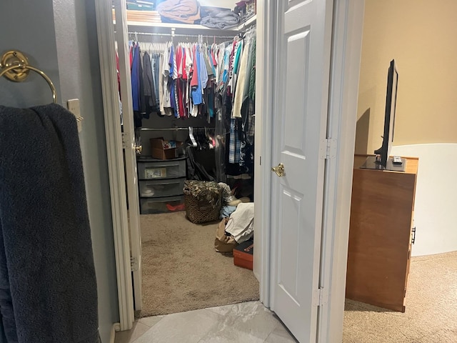 walk in closet featuring light colored carpet