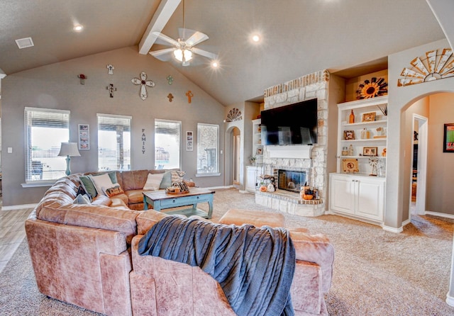 living room with ceiling fan, a fireplace, light colored carpet, and beam ceiling