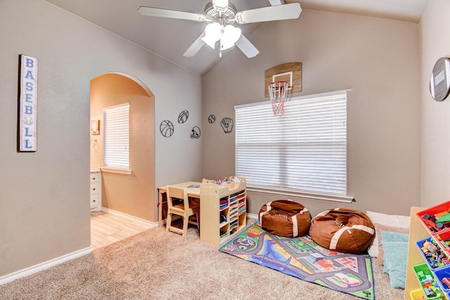 game room featuring vaulted ceiling, plenty of natural light, light colored carpet, and ceiling fan