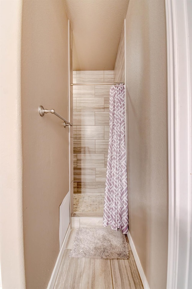 bathroom featuring wood-type flooring and curtained shower