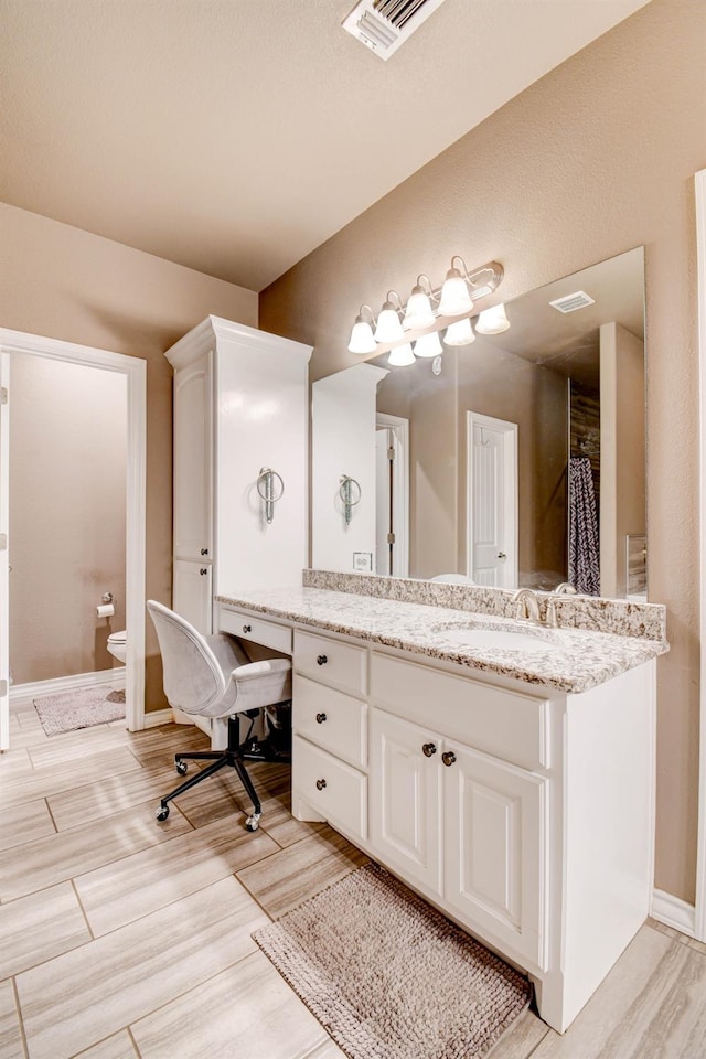 bathroom featuring vanity and toilet