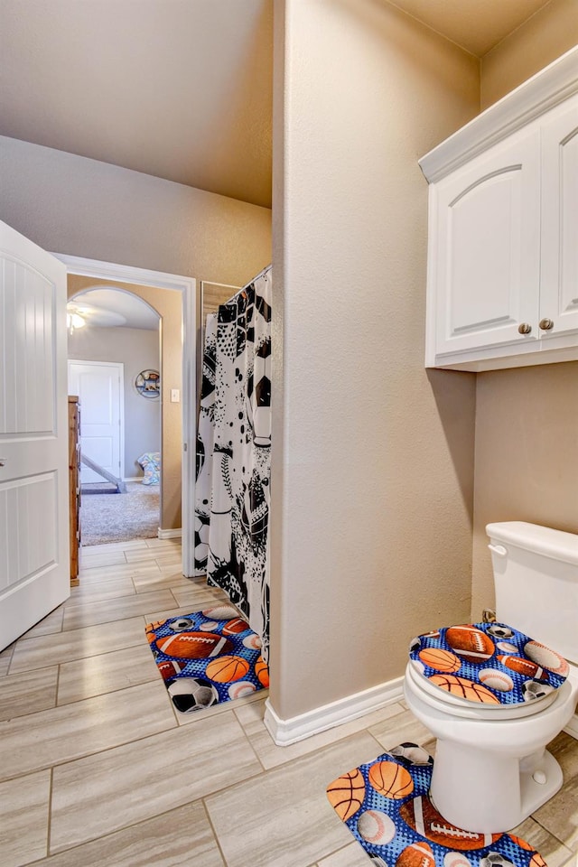 bathroom featuring a shower with curtain and toilet