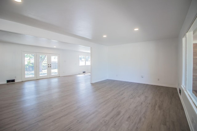 empty room with light hardwood / wood-style floors and french doors