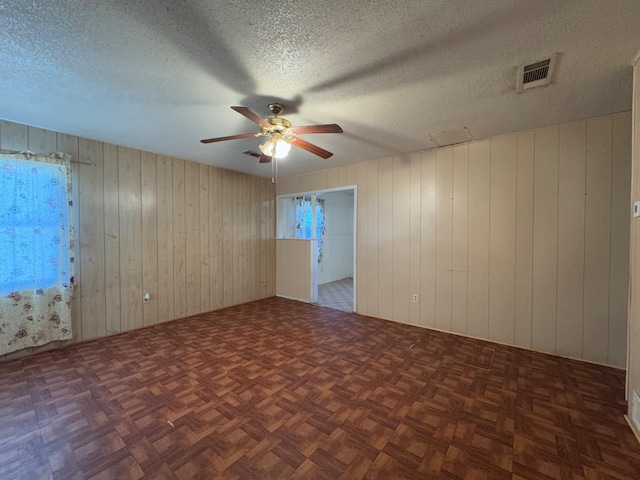 spare room with ceiling fan, a textured ceiling, and dark parquet floors