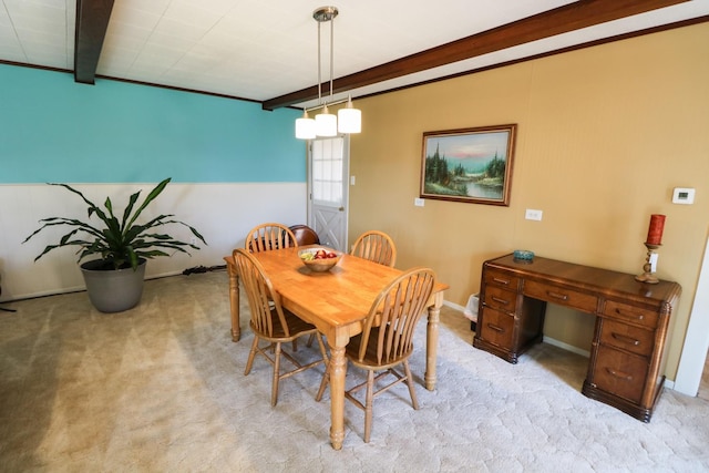 dining space featuring light carpet and beam ceiling