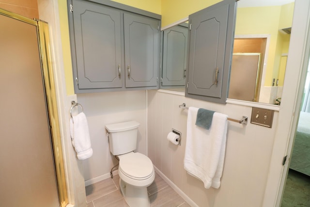 bathroom featuring ensuite bathroom, a stall shower, toilet, and baseboards