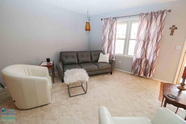 living area featuring light carpet and baseboards