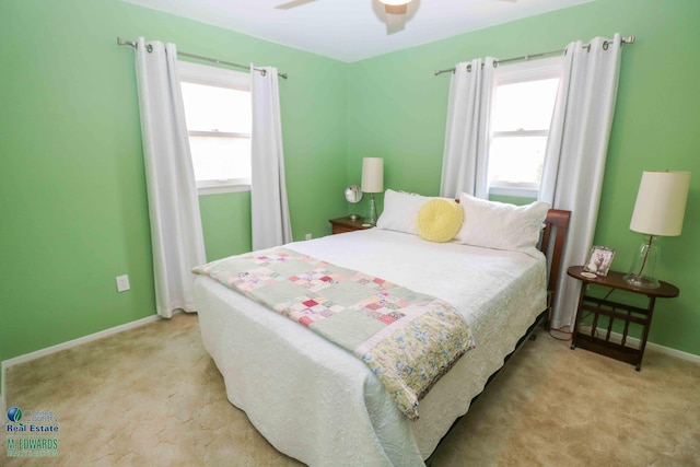 bedroom with baseboards, multiple windows, and light colored carpet