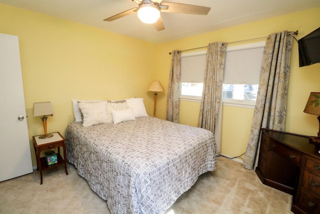 bedroom with a ceiling fan and light colored carpet