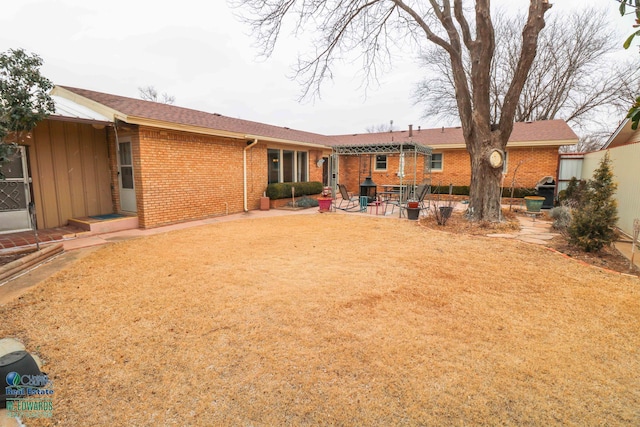 rear view of property featuring brick siding and a patio area