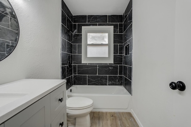 full bathroom featuring tiled shower / bath combo, vanity, hardwood / wood-style flooring, and toilet