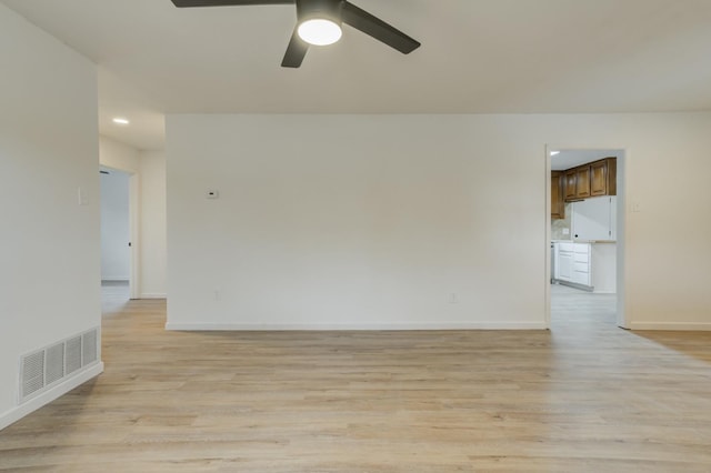 empty room with ceiling fan and light hardwood / wood-style floors