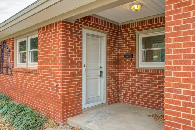 doorway to property featuring brick siding