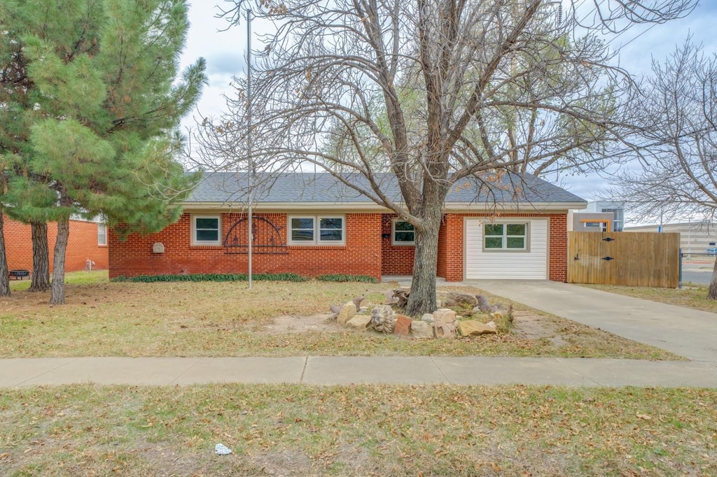 ranch-style house with a front yard and brick siding