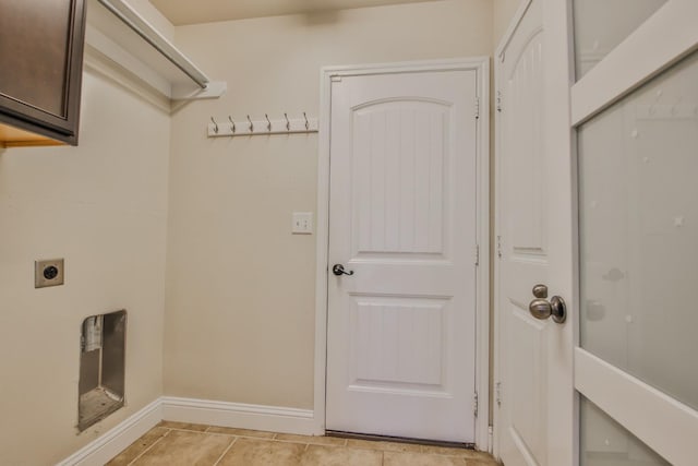 clothes washing area featuring cabinets, light tile patterned flooring, and electric dryer hookup