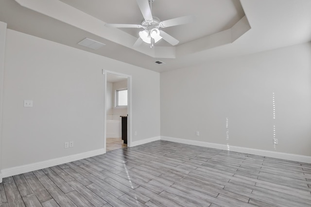 spare room featuring a tray ceiling and ceiling fan