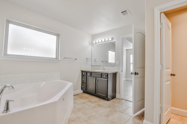 bathroom with tile patterned flooring, vanity, and a bathtub