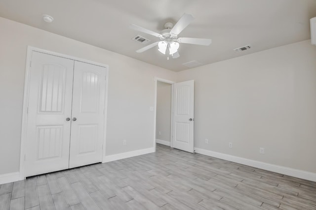 unfurnished bedroom featuring ceiling fan, a closet, and light wood-type flooring