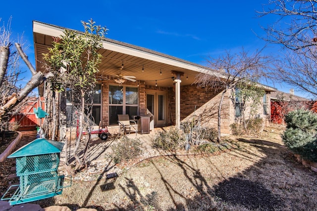 rear view of property with ceiling fan and a patio area