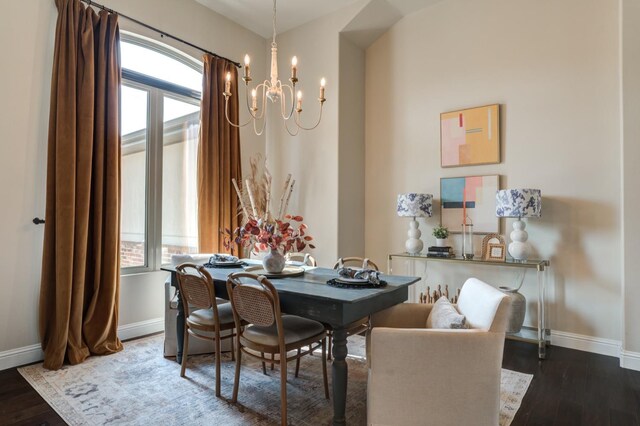 dining area with dark wood-type flooring, plenty of natural light, and an inviting chandelier