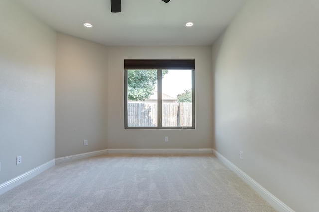 carpeted spare room with ceiling fan