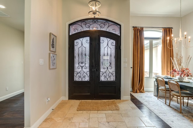 entrance foyer featuring french doors and a notable chandelier