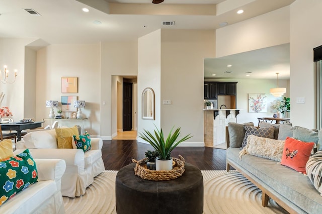 living room with dark hardwood / wood-style flooring and a notable chandelier