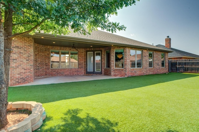 back of property featuring a lawn and a patio