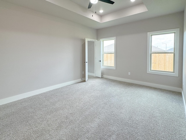 5811 Venita Ave, Lubbock, TX 79407 - spare room featuring a tray ceiling, a ceiling fan, and light colored carpet