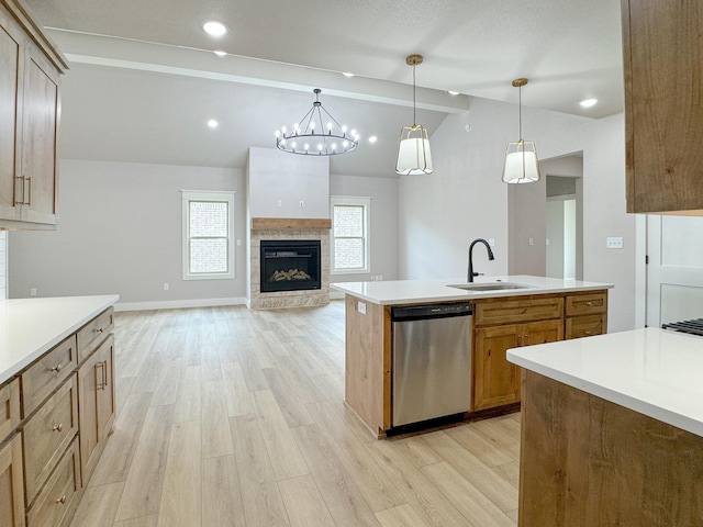 5811 Venita Ave, Lubbock, TX 79407 - kitchen with stainless steel dishwasher, a glass covered fireplace, light wood-type flooring, and light countertops