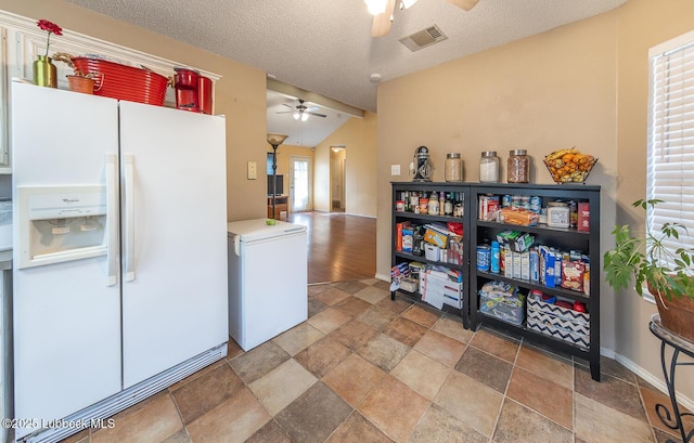 401 Oshkosh Ave, Lubbock, TX 79416 - kitchen with white refrigerator with ice dispenser, a ceiling fan, stone finish floors, fridge, and vaulted ceiling