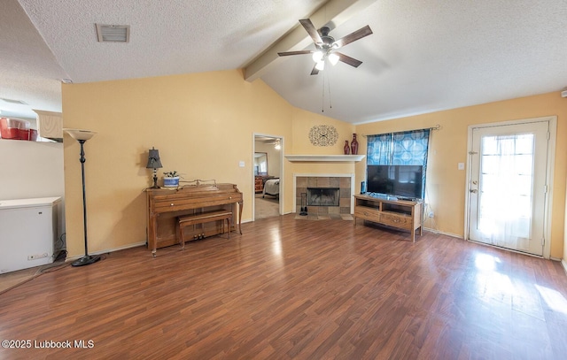 401 Oshkosh Ave, Lubbock, TX 79416 - living room featuring ceiling fan, wood finished floors, a tile fireplace, and a textured ceiling