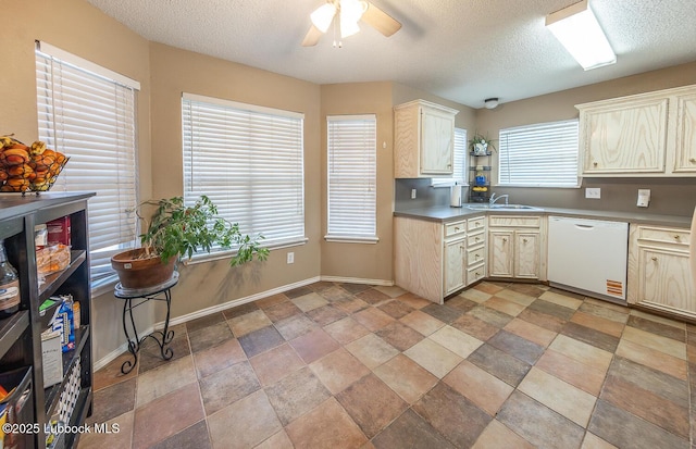 401 Oshkosh Ave, Lubbock, TX 79416 - kitchen featuring white dishwasher, ceiling fan, a textured ceiling, stone finish floors, and cream cabinetry