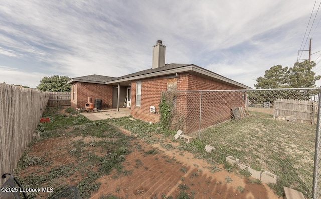 401 Oshkosh Ave, Lubbock, TX 79416 - back of property featuring brick siding, a fenced backyard, a chimney, and a patio area