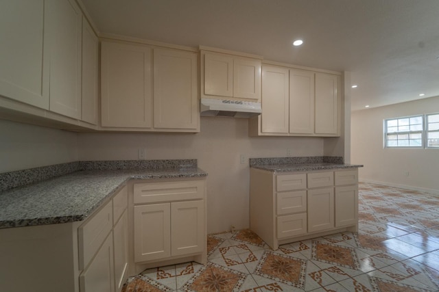 kitchen with light stone counters and white cabinets