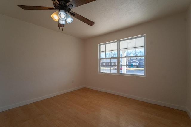 empty room with ceiling fan, a textured ceiling, and light wood-type flooring