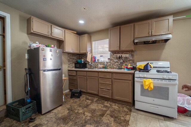 kitchen with sink, stainless steel refrigerator, backsplash, a textured ceiling, and white range with gas cooktop