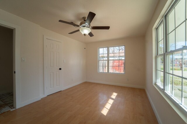 unfurnished room with ceiling fan and light wood-type flooring