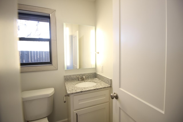 half bathroom featuring vanity and toilet