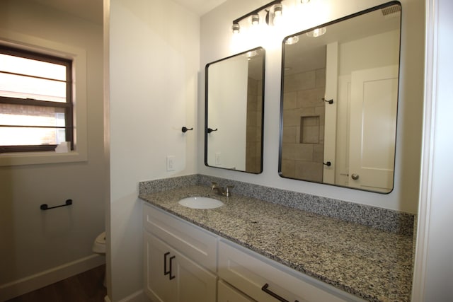 bathroom with vanity, toilet, and baseboards