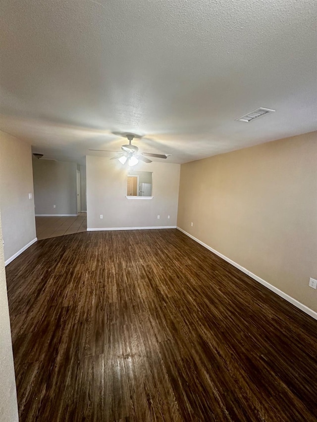 spare room featuring ceiling fan, dark hardwood / wood-style flooring, and a textured ceiling