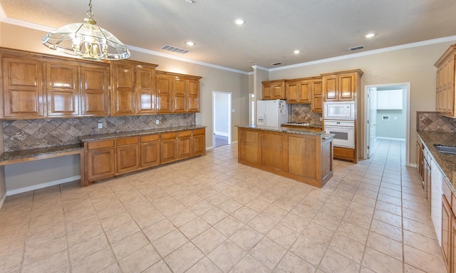 kitchen with a kitchen island, stone countertops, backsplash, hanging light fixtures, and white appliances