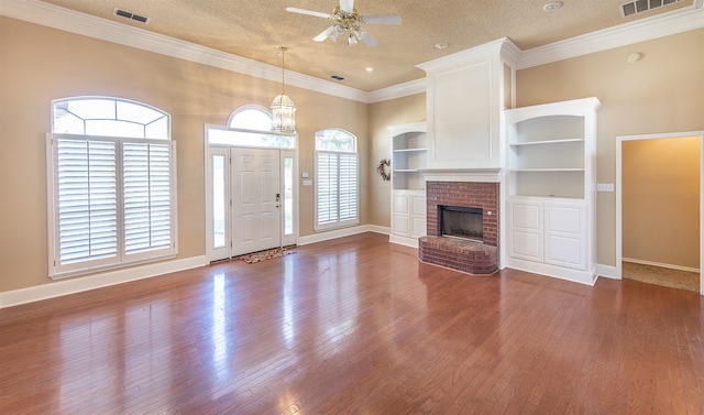 unfurnished living room with a textured ceiling, ornamental molding, ceiling fan, a fireplace, and hardwood / wood-style floors