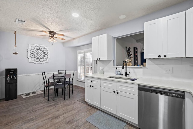 kitchen featuring hardwood / wood-style floors, white cabinetry, sink, and stainless steel dishwasher