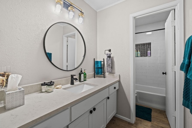 bathroom featuring hardwood / wood-style flooring, vanity, and tiled shower / bath