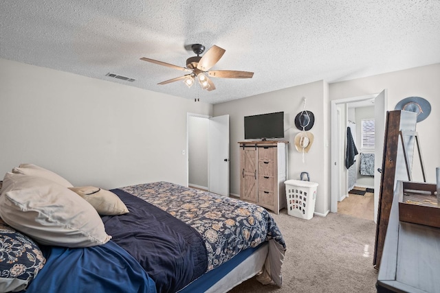 carpeted bedroom with ceiling fan and a textured ceiling