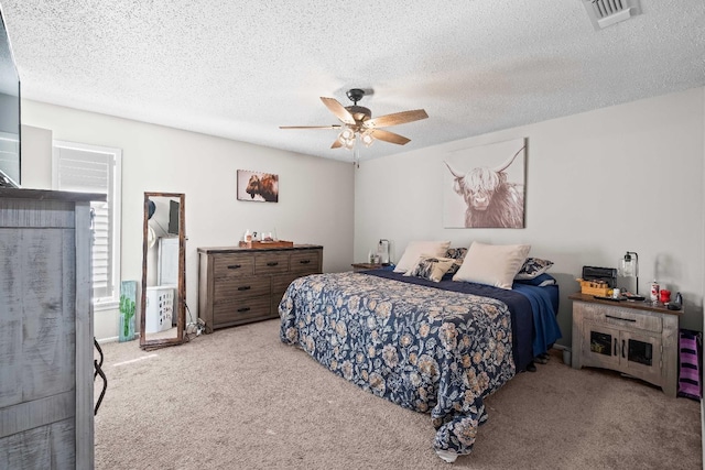 bedroom with light carpet, a textured ceiling, and ceiling fan