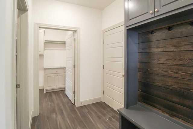 mudroom with dark wood-style flooring and baseboards