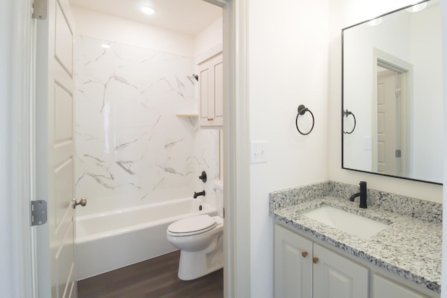 bathroom with wood finished floors, tub / shower combination, vanity, and toilet